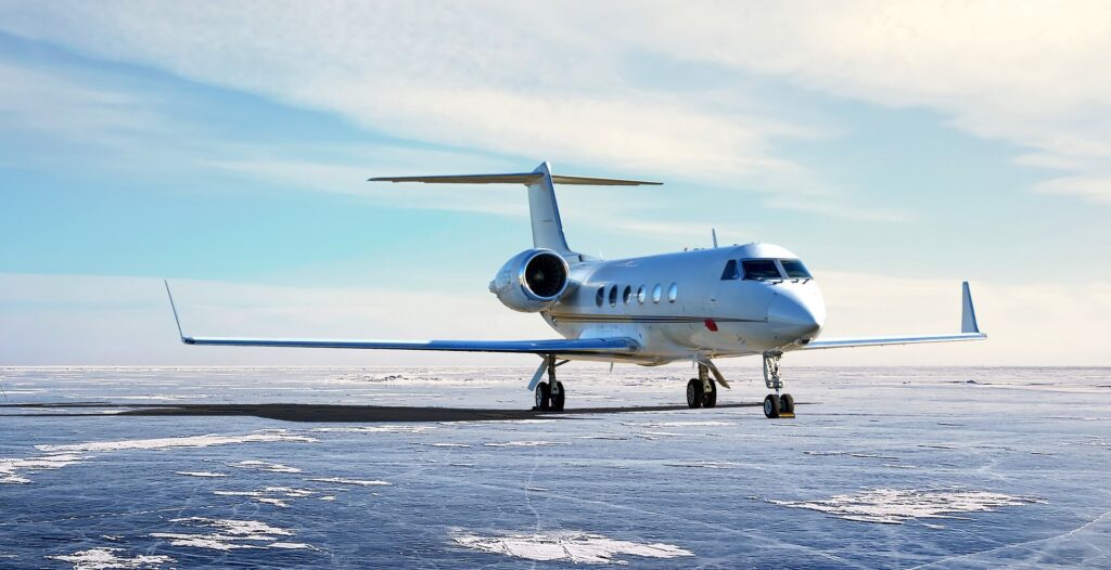A business jet parked on an airport ramp, seen from the front and side.