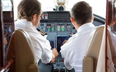 Rear view of pilot and copilot in private jet cockpit